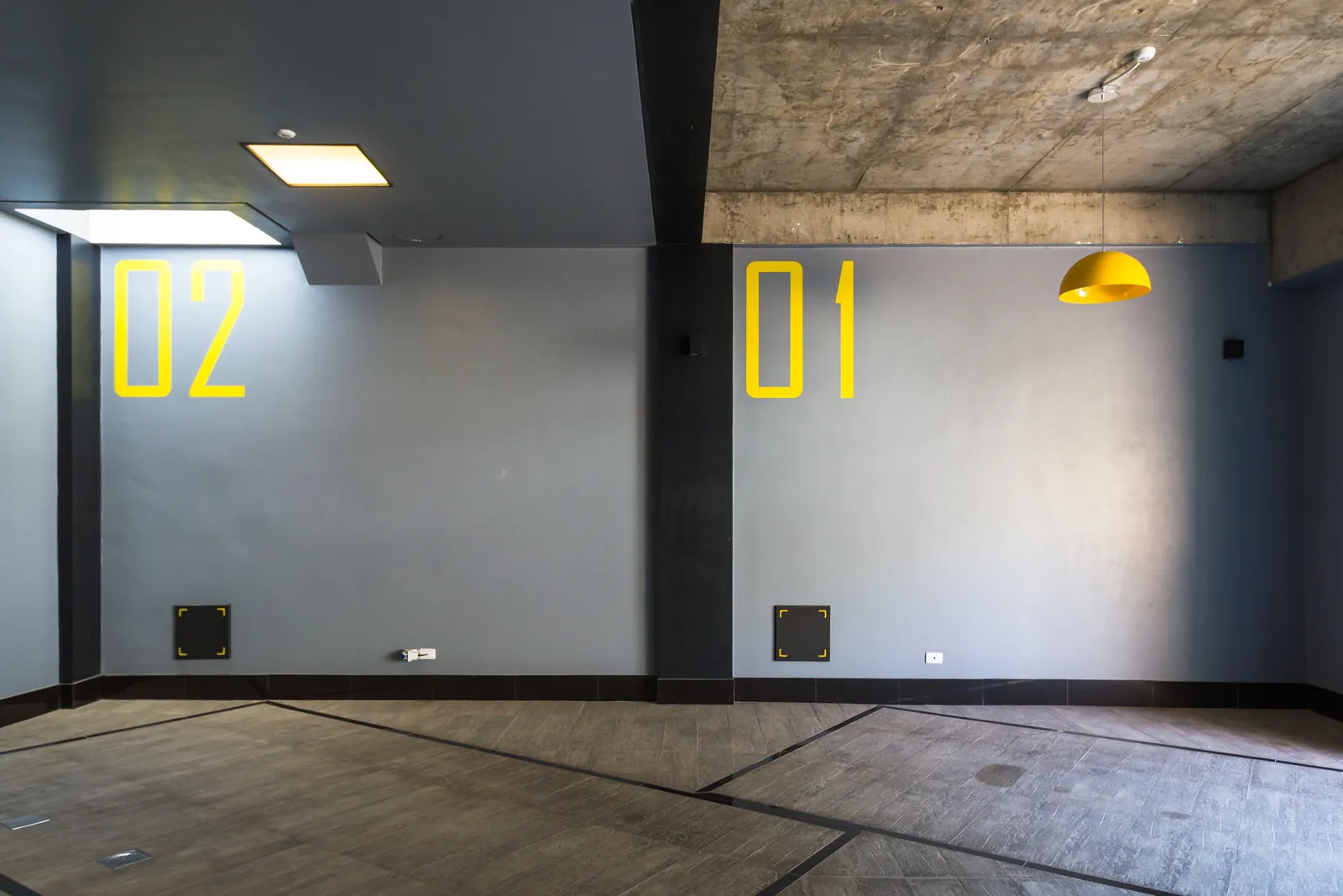 A garagem com as vagas 01 e 02 em amarelo e o teto de concreto.